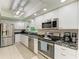 Bright kitchen featuring stainless steel appliances, white cabinets, and modern lighting at 1622 Stafford Ln # 1205, Sarasota, FL 34232