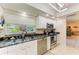Well-lit kitchen features white cabinets, stainless steel appliances, and a granite countertop at 1622 Stafford Ln # 1205, Sarasota, FL 34232