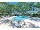 Outdoor community pool surrounded by lush greenery and ample lounge seating at 1622 Stafford Ln # 1205, Sarasota, FL 34232