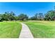 Scenic community walking path through well-manicured green spaces and mature trees at 1622 Stafford Ln # 1205, Sarasota, FL 34232