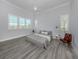 Bright bedroom featuring modern gray decor, wood floors, shutters, and a ceiling fan at 212 Milan W Ave # 1, Venice, FL 34285