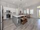 Open-concept kitchen features a kitchen island, dining area, stainless steel appliances, and modern finishes at 212 Milan W Ave # 1, Venice, FL 34285