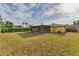 View of a backyard with a screened lanai, lush lawn, and privacy fence, perfect for outdoor enjoyment at 2151 Upton Ave, Sarasota, FL 34232