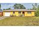 Charming yellow single-story home with an attached garage and well-maintained front lawn at 2151 Upton Ave, Sarasota, FL 34232