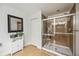 Bathroom with a shower and glass door with tiled walls, plus a storage cabinet at 2177 Weaver Bird Ln, Venice, FL 34292