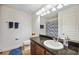 Bathroom with sink, toilet, counter with mirror and shower curtain, and blue accents at 2177 Weaver Bird Ln, Venice, FL 34292