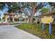 Centennial Park scenery with lush greenery and quaint buildings with tile roofs under large shade trees at 2177 Weaver Bird Ln, Venice, FL 34292