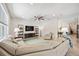 Spacious living room featuring a ceiling fan, neutral-toned walls, and a large comfortable sectional couch at 2177 Weaver Bird Ln, Venice, FL 34292