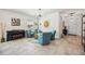 Bright living room featuring neutral walls, tile flooring, modern chandelier and comfortable seating at 2177 Weaver Bird Ln, Venice, FL 34292
