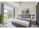 Bright bedroom featuring a ceiling fan, large window overlooking trees, and modern décor at 221 Cosmopolitan Ct, Sarasota, FL 34236