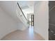 Stylish entryway with curved staircase, elegant tile flooring, and view to the front door at 221 Cosmopolitan Ct, Sarasota, FL 34236