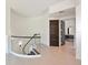 Hallway featuring a curved staircase, neutral tile flooring, and dark brown doors, leading to the bathroom at 221 Cosmopolitan Ct, Sarasota, FL 34236