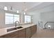 Contemporary kitchen featuring wood cabinetry, a stainless steel dishwasher, quartz countertops and a staircase at 221 Cosmopolitan Ct, Sarasota, FL 34236