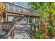 Exterior view of home with large back deck, stairs, and tropical landscaping at 234 85Th St, Holmes Beach, FL 34217