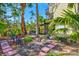 Charming backyard with outdoor seating surrounded by lush trees and foliage at 234 85Th St, Holmes Beach, FL 34217
