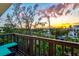 Enjoy sunset views from this covered balcony with turquoise cushioned seating overlooking trees and a canal at 234 85Th St, Holmes Beach, FL 34217
