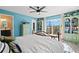 Spacious bedroom with large windows, a ceiling fan, and blue walls; offering a serene and comfortable living space at 234 85Th St, Holmes Beach, FL 34217