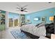 Bright bedroom featuring a ceiling fan, outdoor access, and a view of the surrounding tropical landscape at 234 85Th St, Holmes Beach, FL 34217