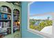 Bedroom view featuring a window overlooking a waterway, lush greenery, and nearby houses at 234 85Th St, Holmes Beach, FL 34217