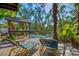 Exterior view of deck with two lawn chairs, a barbecue prep area, and lush tropical landscape at 234 85Th St, Holmes Beach, FL 34217