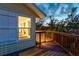 Exterior view of wooden deck with railing outside a home's window overlooking lush landscape at dusk at 234 85Th St, Holmes Beach, FL 34217