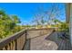 Spacious wooden deck with two Adirondack chairs and views of lush tropical landscaping and a blue sky at 234 85Th St, Holmes Beach, FL 34217