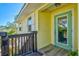 Entry view of a charming yellow home with a glass door and wooden walkway at 234 85Th St, Holmes Beach, FL 34217