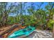 Kayak on the beach surrounded by lush greenery and trees near calm water at 234 85Th St, Holmes Beach, FL 34217