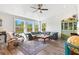 Bright living room with ceiling fan, comfortable seating, and natural light from large windows at 234 85Th St, Holmes Beach, FL 34217