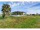 Sprawling backyard showcasing a screened-in pool area, mature palm trees, and lush landscaping, providing a serene retreat at 24017 Peppercorn Rd, Punta Gorda, FL 33955