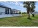 Expansive backyard featuring a screened pool enclosure, lush green lawn, and manicured landscaping, offering a private outdoor oasis at 24017 Peppercorn Rd, Punta Gorda, FL 33955