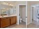 Bathroom featuring wood cabinets, ample counter space, and an adjacent toilet room at 24017 Peppercorn Rd, Punta Gorda, FL 33955