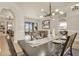 Elegant dining room with modern chandelier, table setting and neutral decor overlooking the outdoor living space at 24017 Peppercorn Rd, Punta Gorda, FL 33955