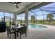 Enclosed patio overlooking the pool and backyard with comfortable seating and dining area for outdoor enjoyment at 24017 Peppercorn Rd, Punta Gorda, FL 33955
