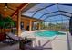 Relaxing screened-in pool area with lounge chairs, dining, and lush landscaping, perfect for outdoor entertaining and enjoying the Florida sunshine at 24017 Peppercorn Rd, Punta Gorda, FL 33955