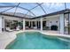 Inviting outdoor pool surrounded by lounge seating, a dining area, and large sliding glass doors for seamless indoor-outdoor living at 24017 Peppercorn Rd, Punta Gorda, FL 33955