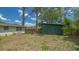 View of the backyard from property showing back of the house and green shed at 275 Burke Rd, Venice, FL 34293