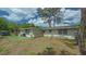 Backyard of property showing partial house and green space with mature trees at 275 Burke Rd, Venice, FL 34293