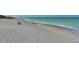 Expansive view of a tranquil beach with turquoise water and soft sand under a clear sky at 275 Burke Rd, Venice, FL 34293
