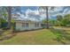 Lovely exterior elevation, mature trees and lawn showcase the property's curb appeal at 275 Burke Rd, Venice, FL 34293