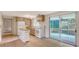 Well-lit kitchen featuring white appliances, a compact island, and a seamless transition to the screened-in porch at 275 Burke Rd, Venice, FL 34293