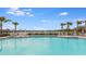 Inviting swimming pool area with lounge chairs, umbrellas and palm trees overlooks a beautiful lake at 2812 Rock Sound St, Bradenton, FL 34208