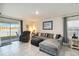 Cozy living room with large windows, access to the patio, a comfortable sectional, and ceramic tile floors at 2812 Rock Sound St, Bradenton, FL 34208