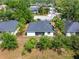 Rear view of home with dark roof surrounded by lush greenery and well-manicured landscaping at 2840 S Shade Ave, Sarasota, FL 34239
