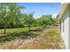 Spacious grassy backyard featuring mature trees and partial home view at 2840 S Shade Ave, Sarasota, FL 34239