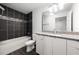 Modern bathroom featuring a dark tile accent wall over the tub and granite vanity at 2840 S Shade Ave, Sarasota, FL 34239