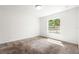 Cozy bedroom with plush carpeting and a large window overlooking a lush backyard at 2840 S Shade Ave, Sarasota, FL 34239