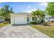 Charming single-story home featuring a well-maintained lawn, palm trees, and a brick driveway leading to an attached garage at 2840 S Shade Ave, Sarasota, FL 34239