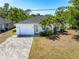 Lovely one-story home showcasing a brick driveway, attached garage, and lush tropical landscaping at 2840 S Shade Ave, Sarasota, FL 34239