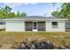 Back of the home featuring a screened-in patio and grassy yard at 2840 S Shade Ave, Sarasota, FL 34239
